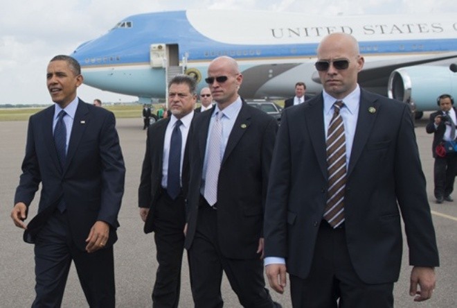 US President Barack Obama (L), surrounded by US Secret Service agents, walks to greet guests upon arrival on Air Force One at Tampa International Airport in Tampa, Florida, on April 13, 2012. Obama arrived in Tampa to speak at the Port of Tampa, before continuing to the Summit of the Americas in the Colombian city of Cartagena. AFP PHOTO/Saul LOEB (Photo credit should read SAUL LOEB/AFP/Getty Images)
