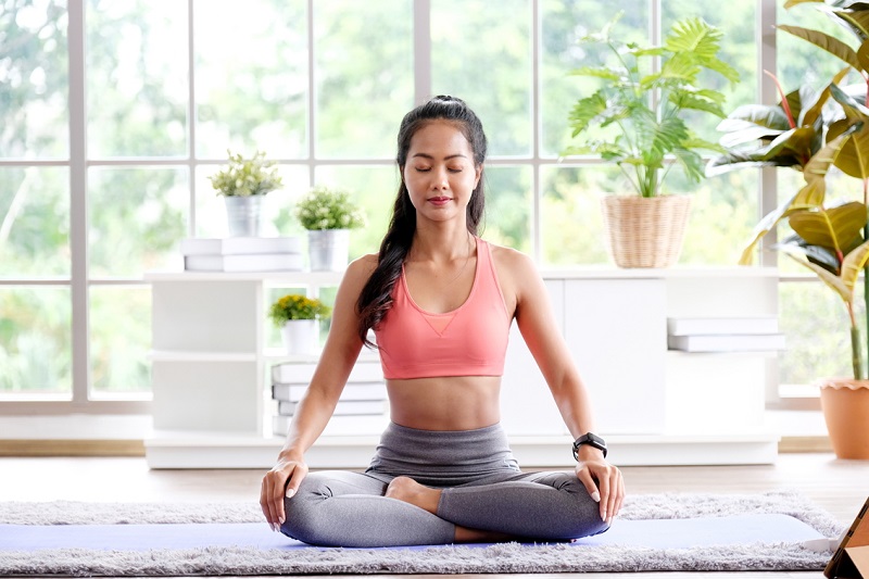 Asian woman practice yoga meditation exercise at home, Young asia female sitting on mat for relaxed yoga posture in the morning , exercise at home, wellbeing, mental health care